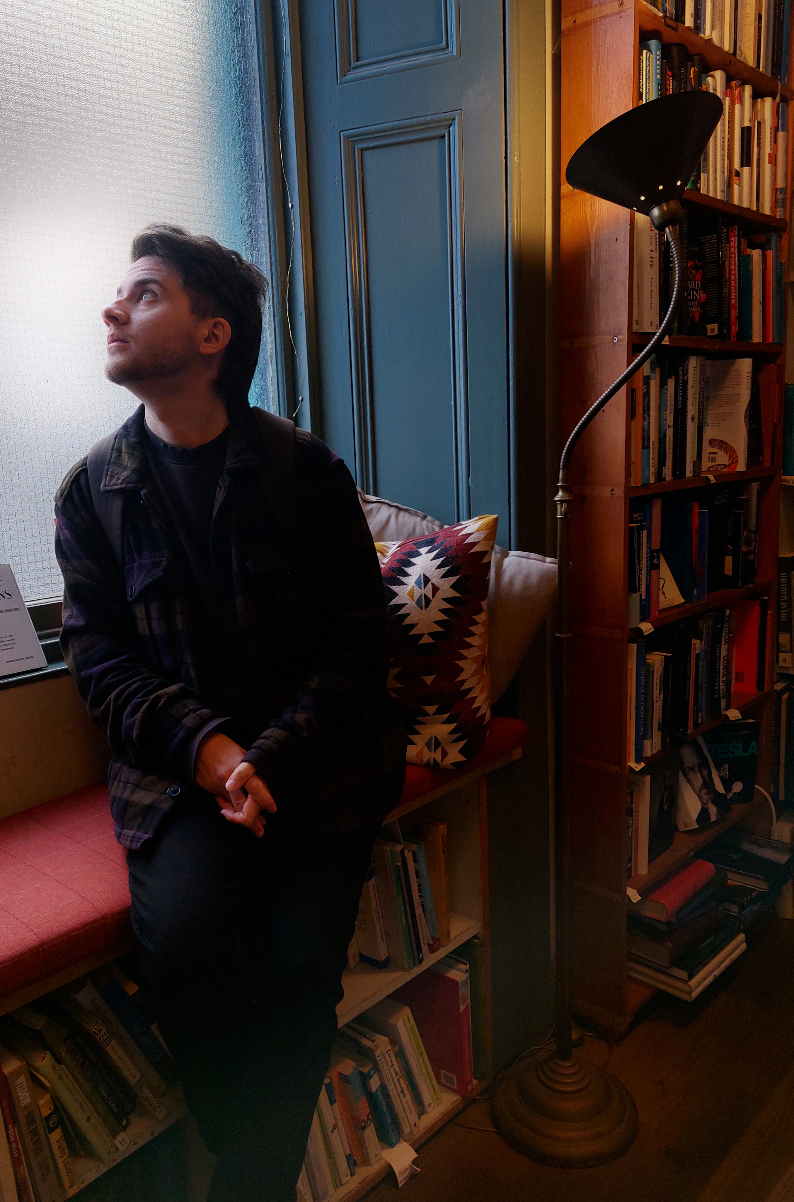 Man sitting by a window in a bookstore